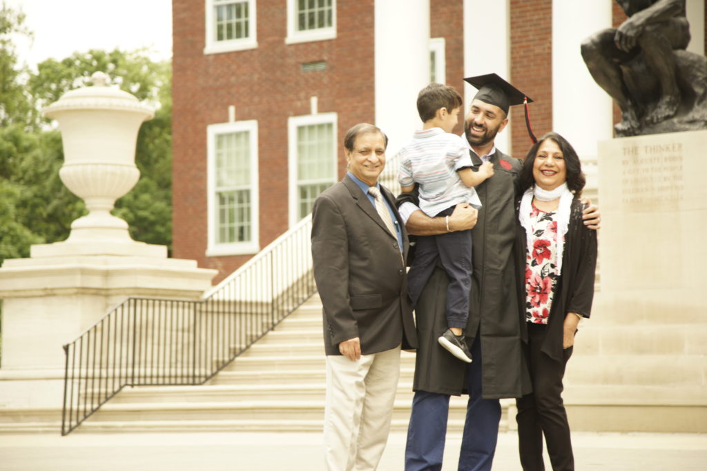 uofl online programs graduate with parents and son/family outside campus in cap and gown