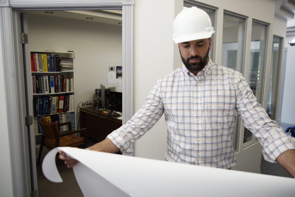 online program student working with hardhat and blueprint